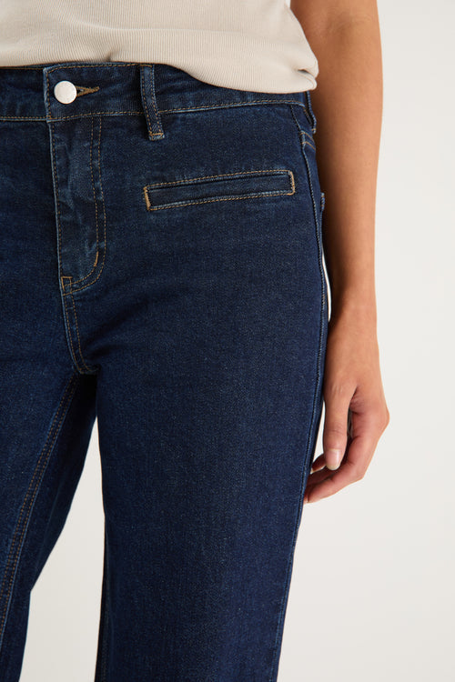 model wearing dark denim jean and white top 