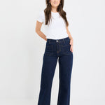 Woman wearing a white t-shirt and dark blue jeans on a white background