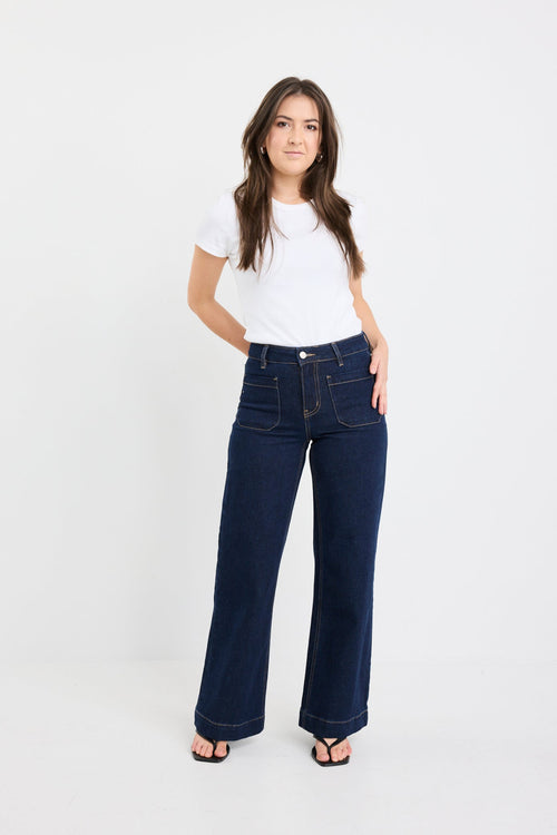 Woman wearing a white t-shirt and dark blue jeans on a white background