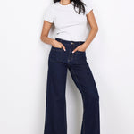 Woman wearing a white t-shirt and dark blue jeans on a white background