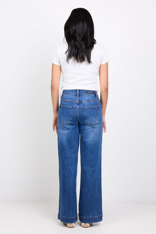 Person wearing blue jeans and a white shirt on a white background