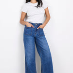 Woman wearing a white t-shirt and blue jeans on a white background