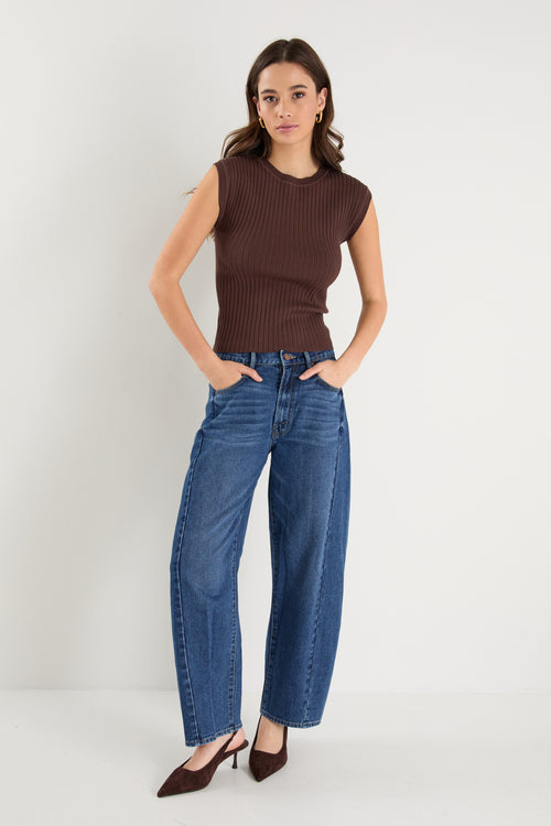 model wears a brown rib knit with blue jeans