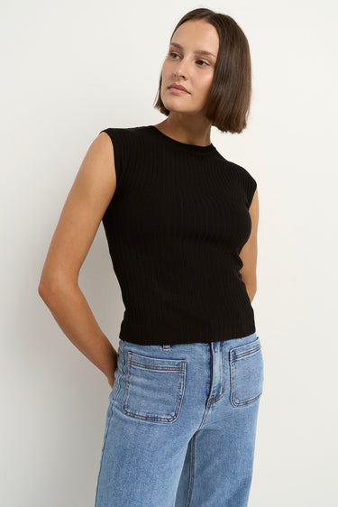 Woman wearing a fitted black ribbed knit tank top with a crew neckline, styled casually with high-waisted light blue denim jeans.