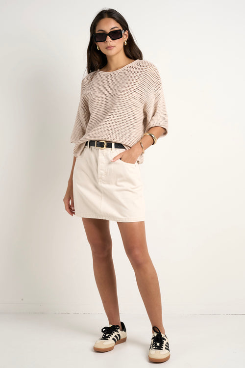 model wears a beige knit t shirt