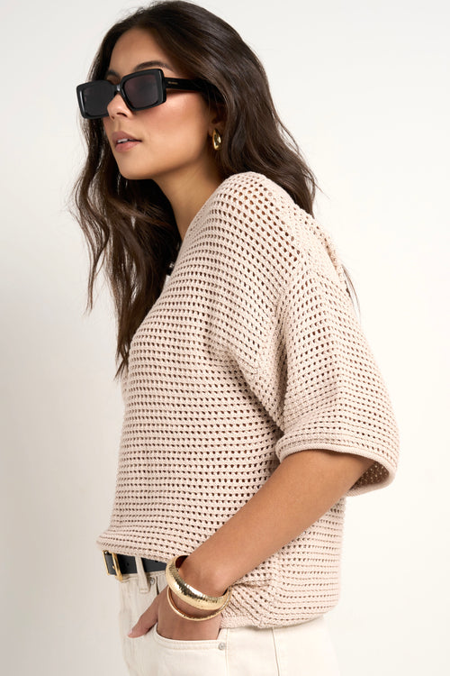 model wears a beige knit t shirt