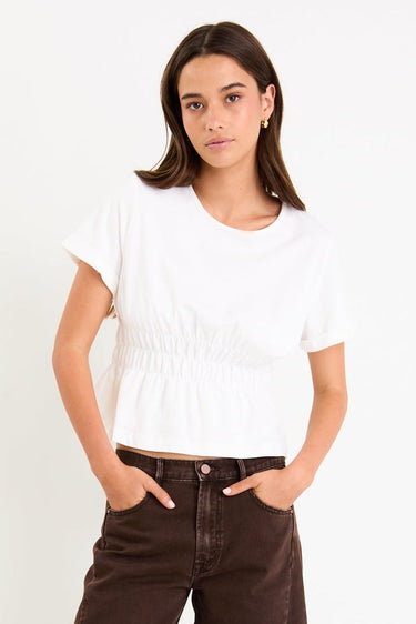 Woman wearing a white t-shirt and brown pants on a white background