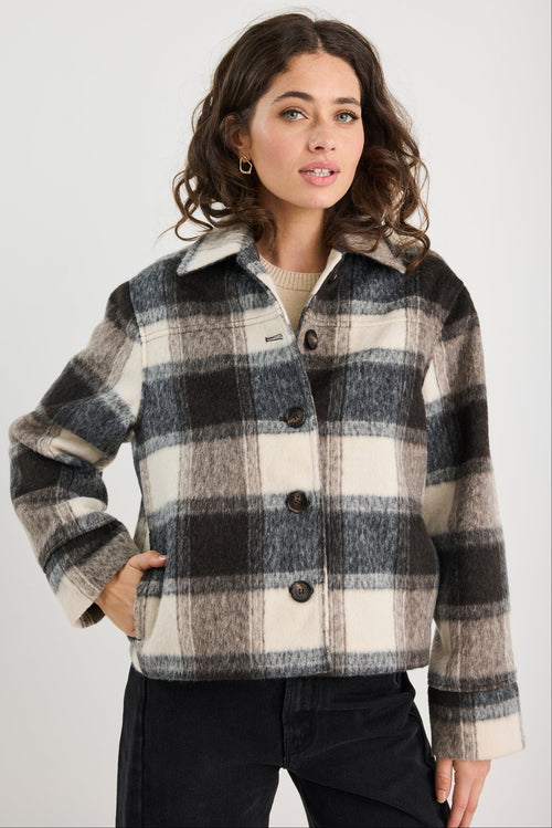 Woman wearing a plaid jacket on a white background