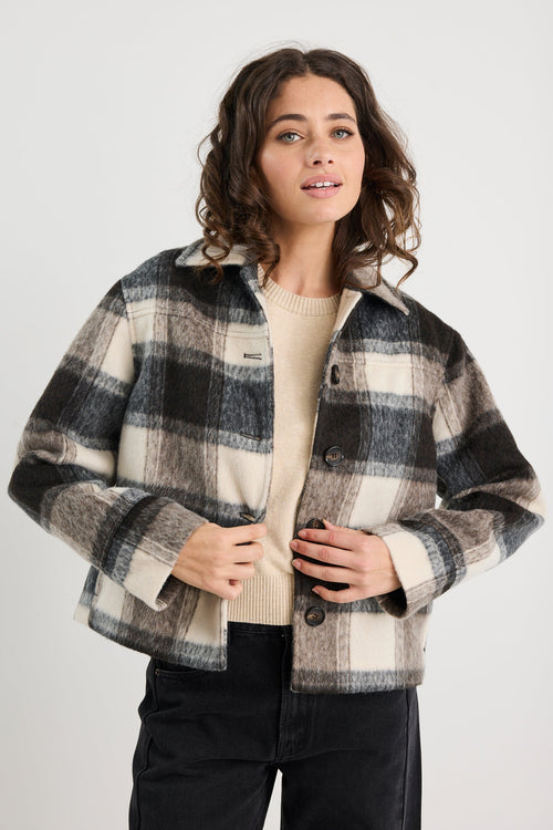 Woman wearing a plaid jacket on a white background