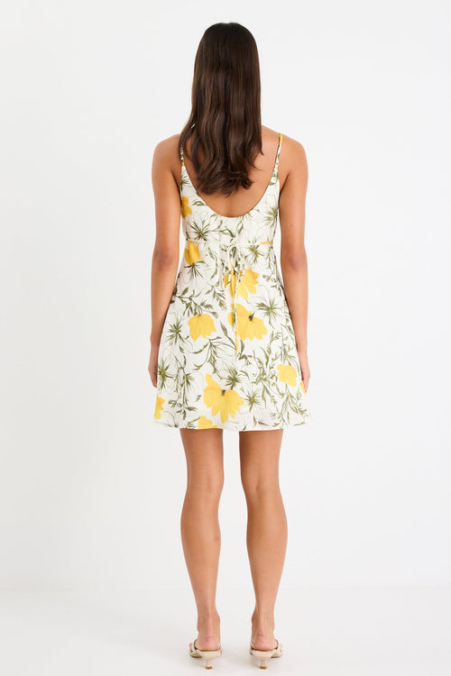 Mini floral bias dress with adjustable straps and a soft, floaty fit, styled with heels and delicate accessories.
