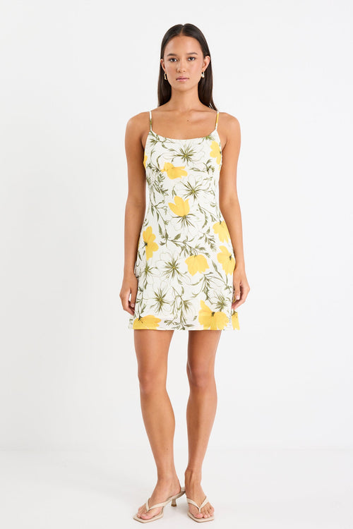 Mini floral bias dress with adjustable straps and a soft, floaty fit, styled with heels and delicate accessories.