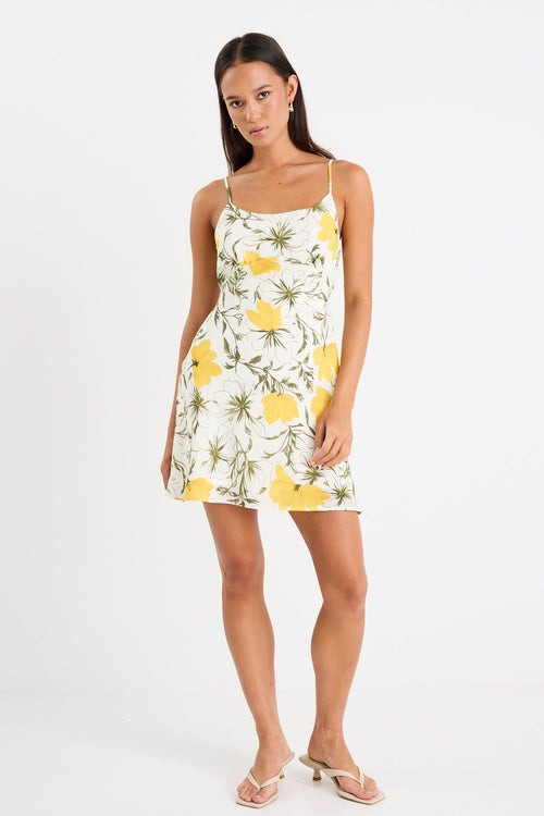 Mini floral bias dress with adjustable straps and a soft, floaty fit, styled with heels and delicate accessories.