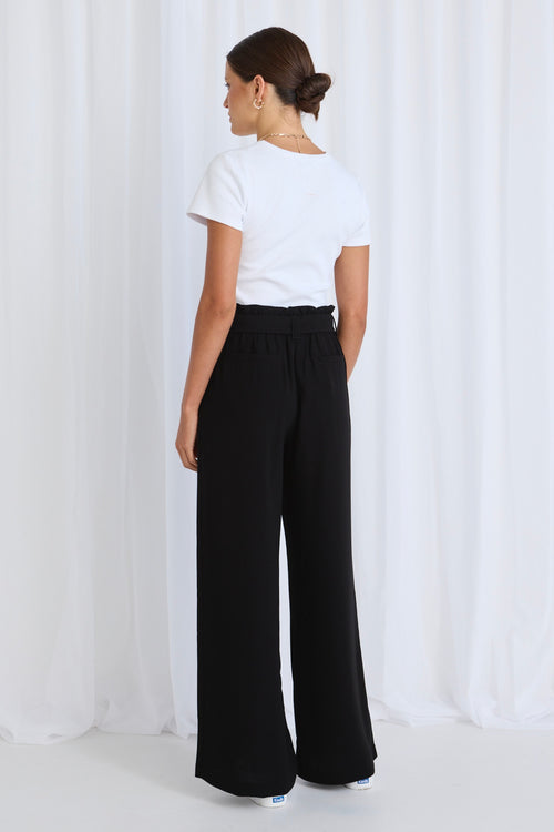 Model wears a black pant with white tee