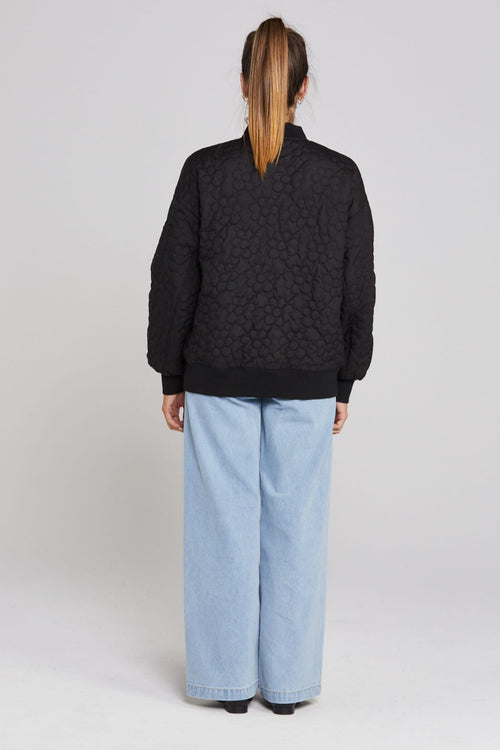 Model wears black quilted bomber jacket 