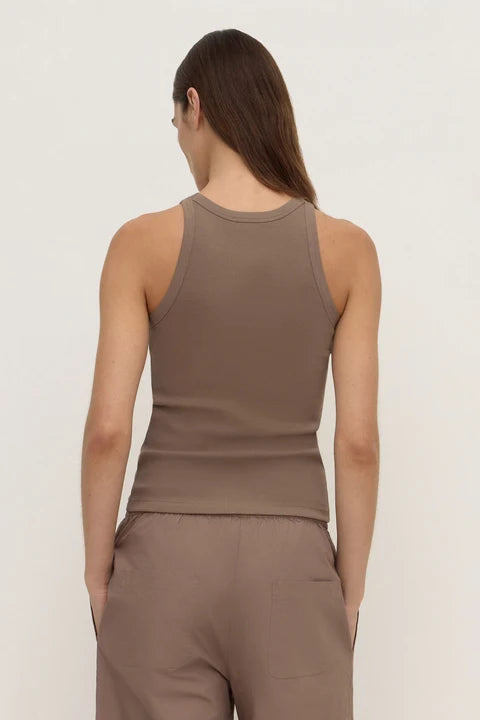 A woman shown from the back wearing a fitted sleeveless ribbed tank top and matching pants in a warm taupe-brown color, against a plain light background.