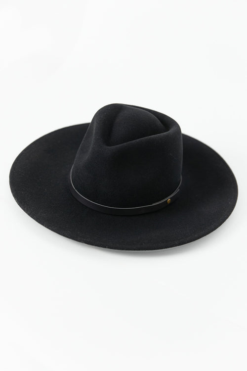 Woman wearing a black hat against a white background