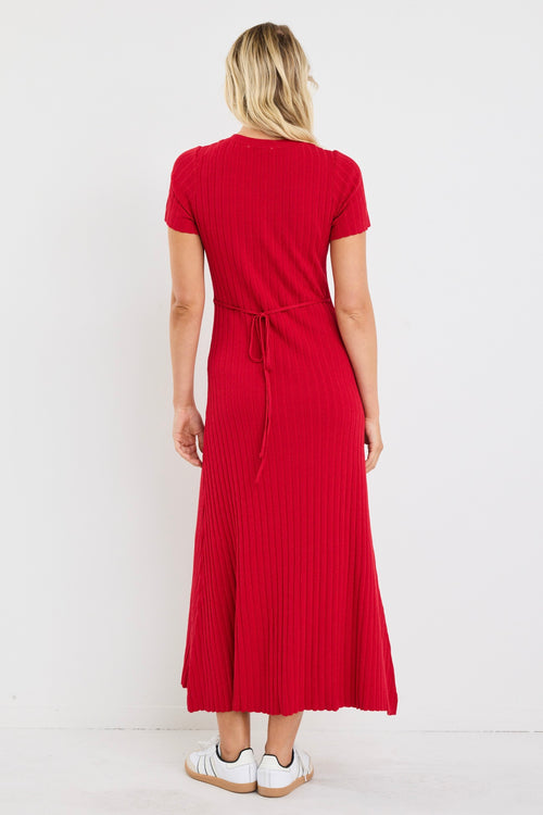 Woman wearing a bright red, ribbed knit dress with short sleeves and crew neckline, styled with white sneakers.