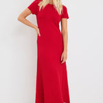 Woman wearing a bright red, ribbed knit dress with short sleeves and crew neckline, styled with white sneakers.