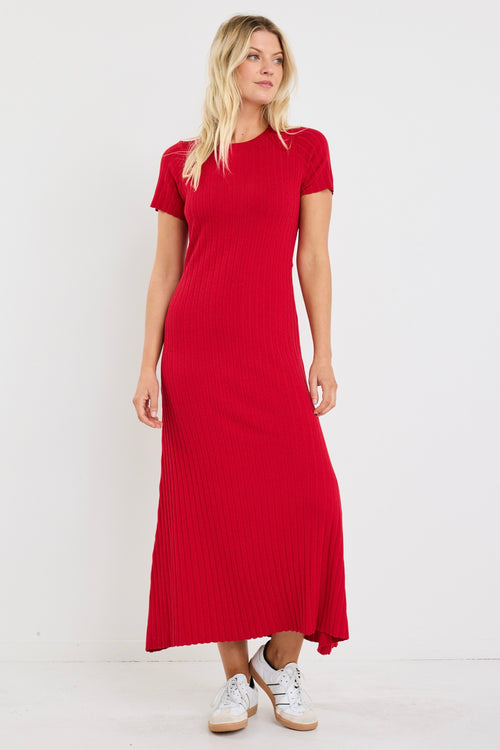Woman wearing a bright red, ribbed knit dress with short sleeves and crew neckline, styled with white sneakers.