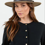 Woman wearing a brown hat against a white background
