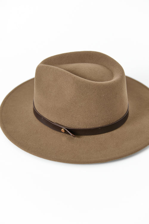Woman wearing a brown hat against a white background