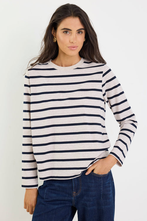 Woman wearing a striped sweater and jeans against a white background