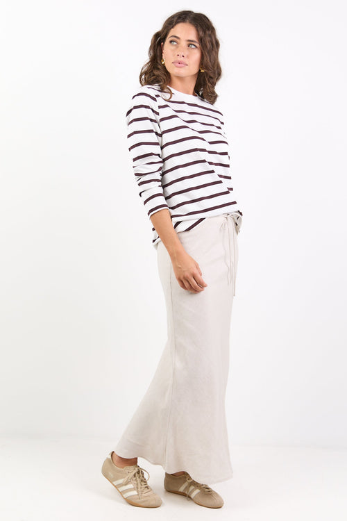 Person wearing a striped shirt and white pants on a white background