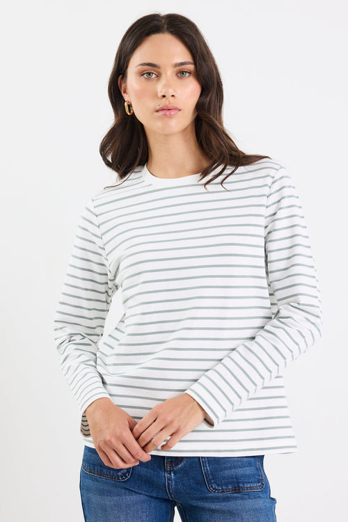 Woman wearing a striped sweater and blue jeans on a white background