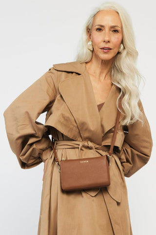 model wears a tan crossbody bag