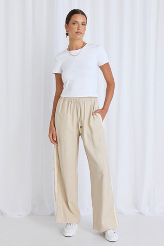 model wears beige pants and a white tee