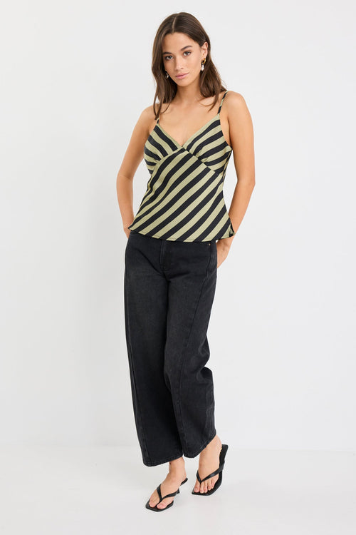 Woman wearing a khaki and black diagonal stripe satin cami with thin straps and a bias-cut silhouette.
