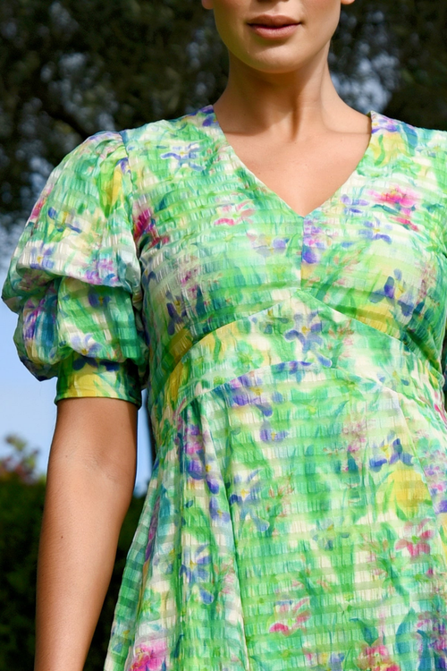 model wears green floral midi dress