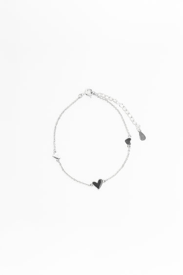 Silver bracelet with heart-shaped charms on a white background