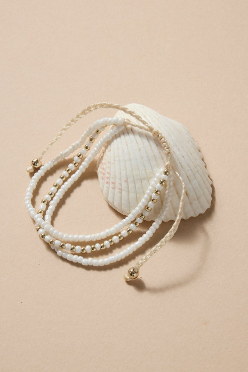 Beige bracelet with pearls on a beige background