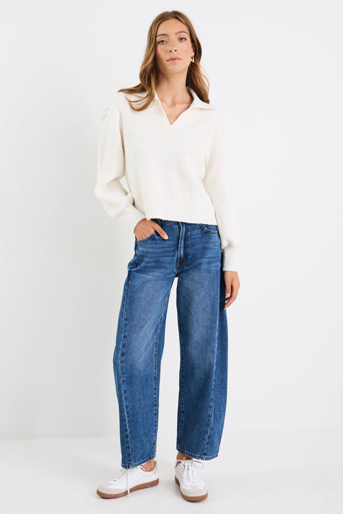 Woman wearing a white blouse and blue jeans on a white background