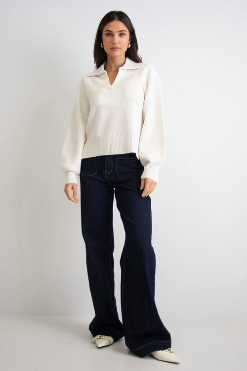 model wears a white collar knit with dark blue jeans