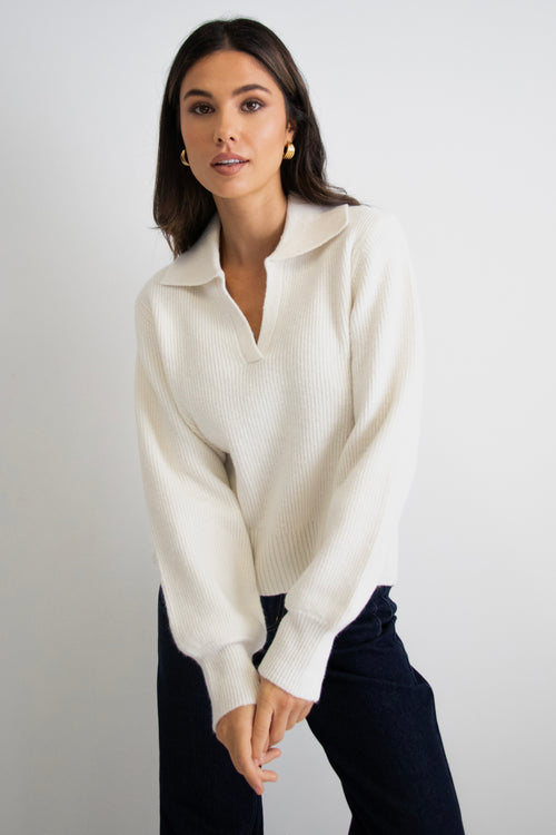model wears a white collar knit with dark blue jeans