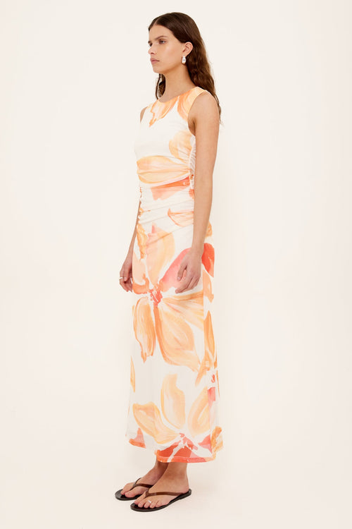 woman wearing a peach shirred midi dress