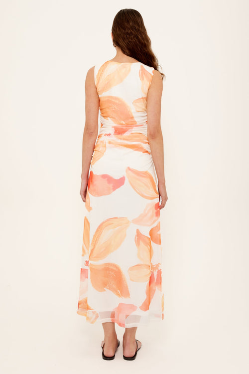 woman wearing a peach shirred midi dress
