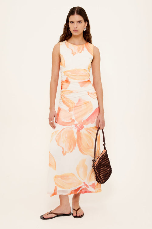 woman wearing a peach shirred midi dress