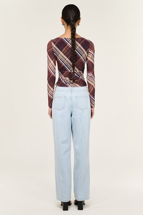 Person wearing a plaid shirt and light blue jeans from behind on a white background