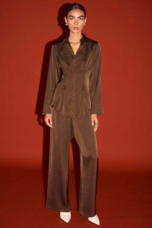 Woman wearing a brown outfit against a red background