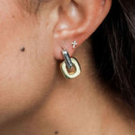 Close-up of U-shaped two tone gold and silver hoop earrings.