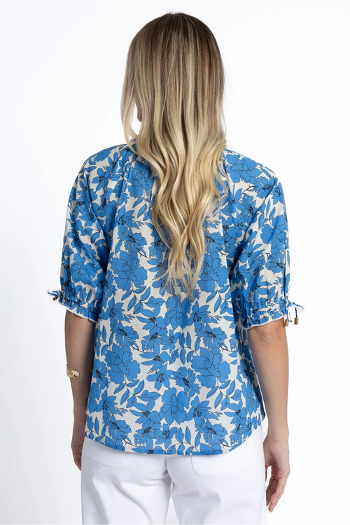 Woman wearing a blue and white floral blouse