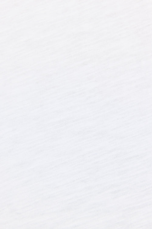 A close-up of a white textured fabric with subtle diagonal ribbing.