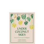 Book cover of 'Under Coconut Skies' with leaf design on a beige background