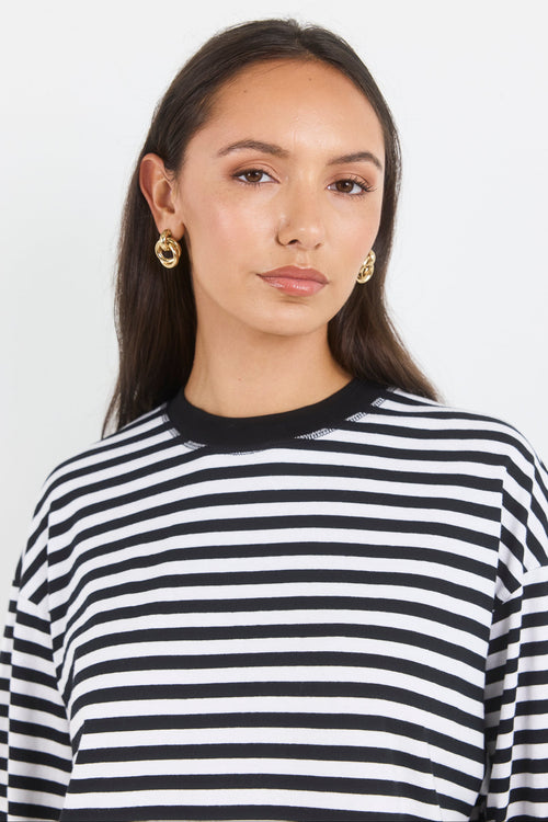 Woman wearing a black and white striped shirt against a plain background