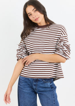 Woman wearing a striped shirt and jeans on a white background