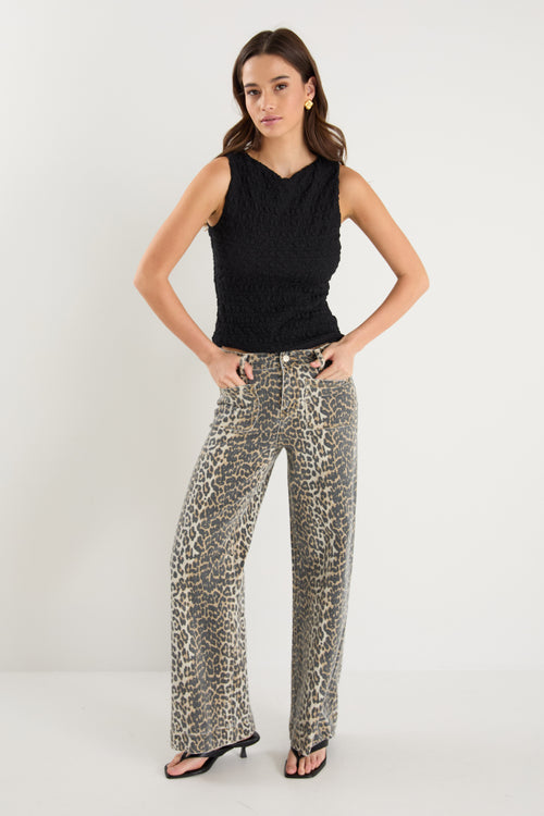 model wearing animal print jeans and a black top 