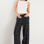 model wears a black wide leg pant with a white tank top